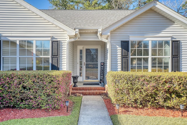 entrance to property featuring a shingled roof