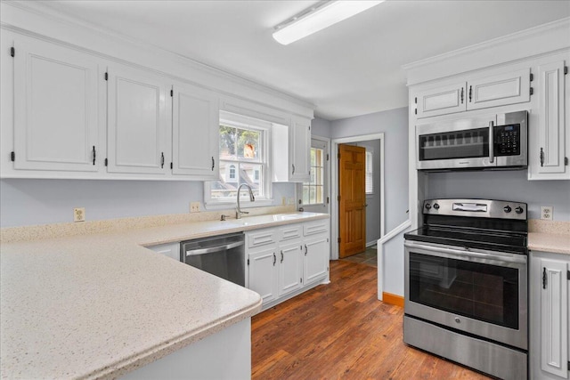 kitchen with dark hardwood / wood-style flooring, white cabinetry, sink, and appliances with stainless steel finishes