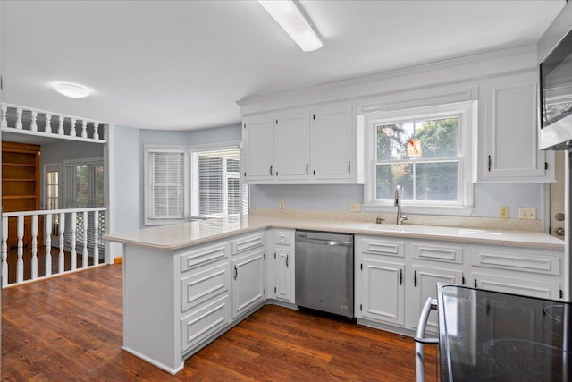 kitchen featuring kitchen peninsula, white cabinets, dark wood-type flooring, dishwasher, and range