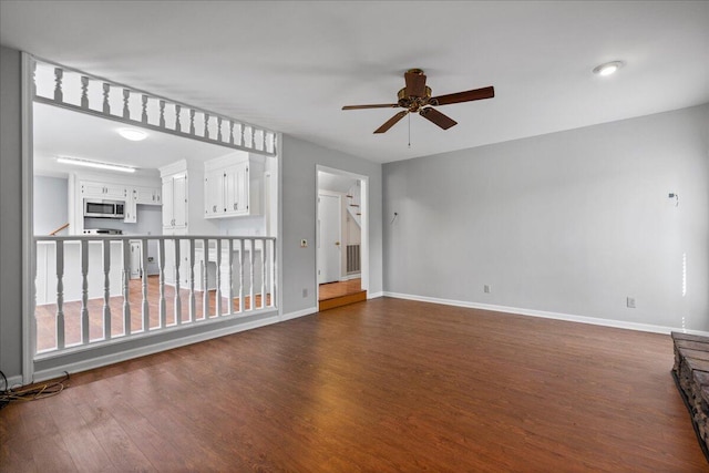 spare room with ceiling fan and dark hardwood / wood-style flooring