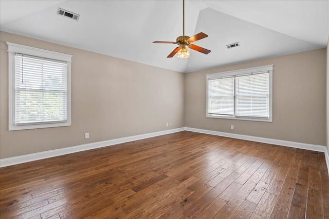 empty room featuring dark hardwood / wood-style flooring, vaulted ceiling, and ceiling fan