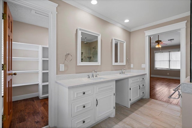 bathroom featuring ceiling fan, vanity, ornamental molding, and hardwood / wood-style flooring