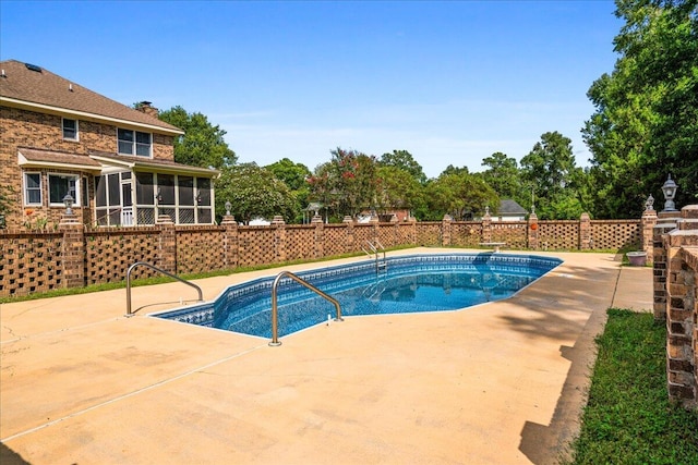 view of swimming pool featuring a sunroom and a patio area