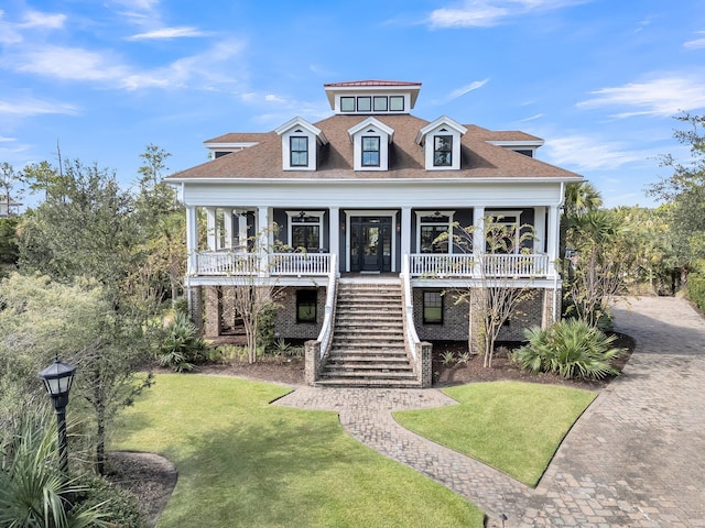 coastal inspired home with covered porch and a front yard