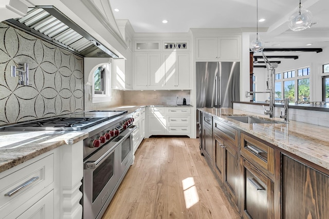 kitchen with sink, white cabinetry, stainless steel appliances, beamed ceiling, and decorative backsplash