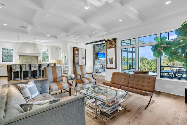 living room featuring light hardwood / wood-style floors, beamed ceiling, coffered ceiling, and a fireplace