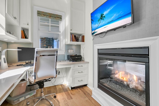 office space featuring light hardwood / wood-style floors and built in desk