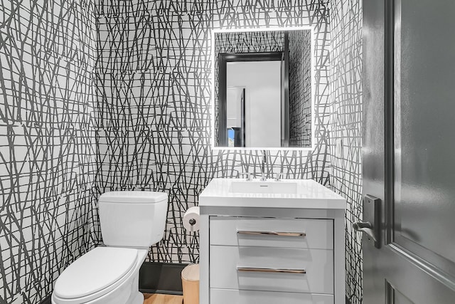 bathroom featuring tile walls, vanity, and toilet