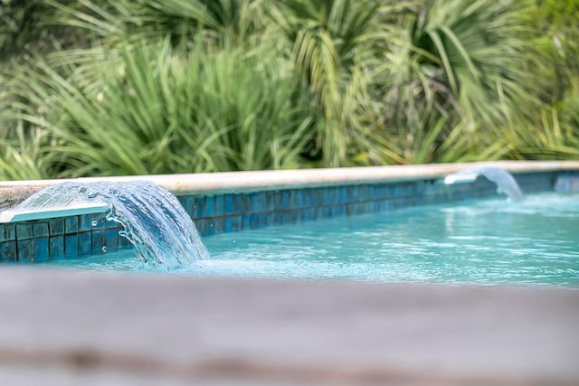 view of swimming pool featuring pool water feature