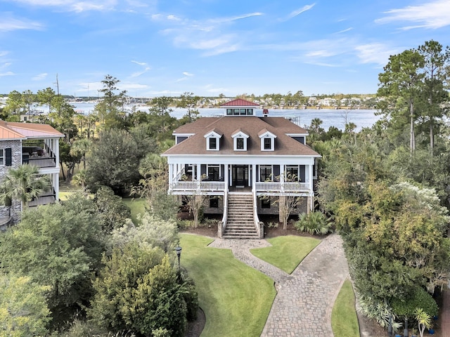 view of front of property featuring a front lawn, a water view, and a porch