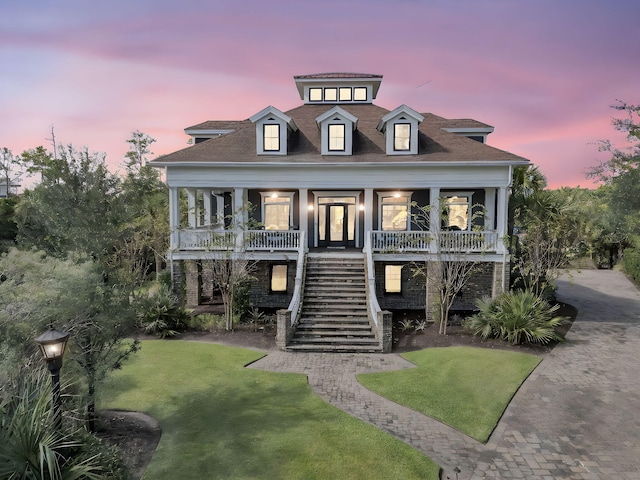 raised beach house with covered porch and a yard