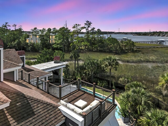 deck at dusk featuring a water view and outdoor lounge area