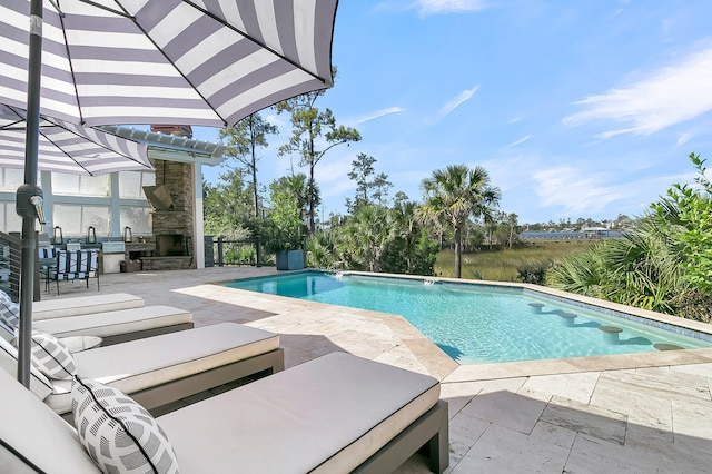 view of pool featuring a patio area and an outdoor stone fireplace