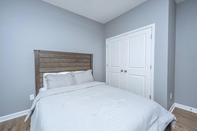 bedroom with baseboards and wood finished floors