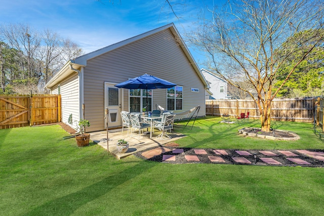 rear view of property with a gate, a fenced backyard, a lawn, and a patio