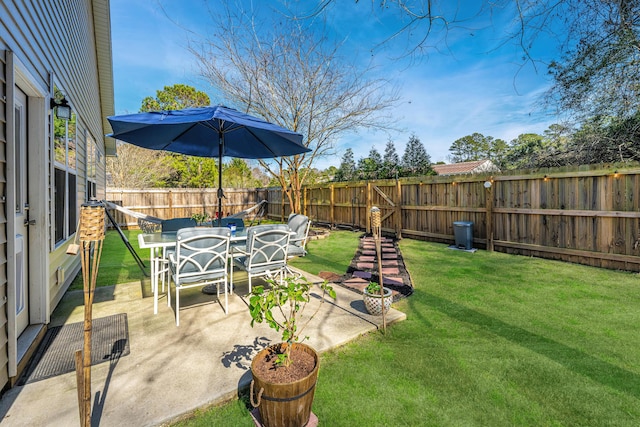 view of yard with outdoor dining space, a fenced backyard, and a patio