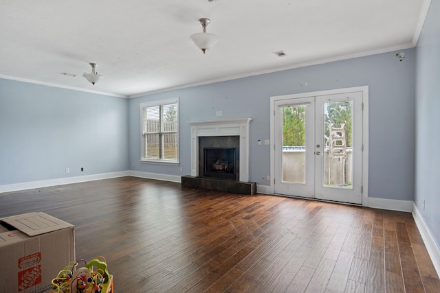 unfurnished living room featuring dark hardwood / wood-style flooring, ornamental molding, a fireplace, and french doors