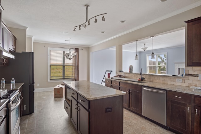 kitchen featuring dark brown cabinetry, sink, pendant lighting, a kitchen island, and appliances with stainless steel finishes