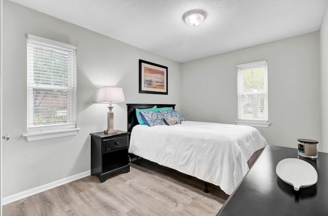 bedroom featuring light hardwood / wood-style flooring and a textured ceiling