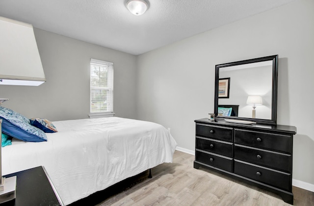 bedroom with light hardwood / wood-style flooring and a textured ceiling