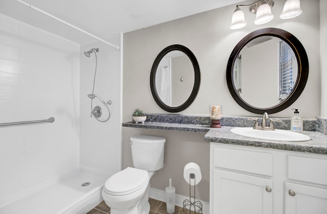 bathroom with vanity, a shower, toilet, and tile patterned flooring