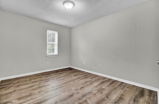 empty room with a textured ceiling and hardwood / wood-style flooring