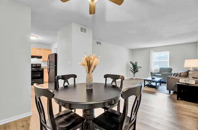 dining space featuring a textured ceiling, light wood-type flooring, and ceiling fan