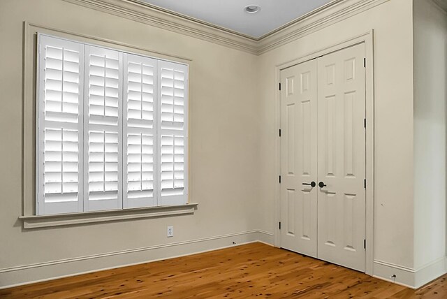 4252 Faber Place Dr Unit 203, North Charleston, SC 29405 - unfurnished bedroom with wood finished floors, a closet, baseboards, and ornamental molding