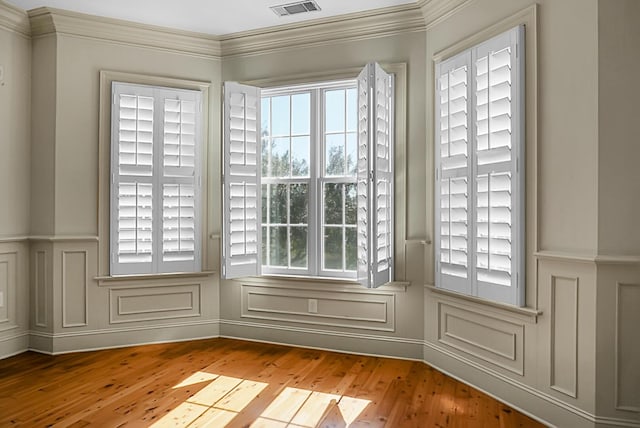 4252 Faber Place Dr Unit 203, North Charleston, SC 29405 - empty room featuring a decorative wall, hardwood / wood-style floors, ornamental molding, and a wainscoted wall