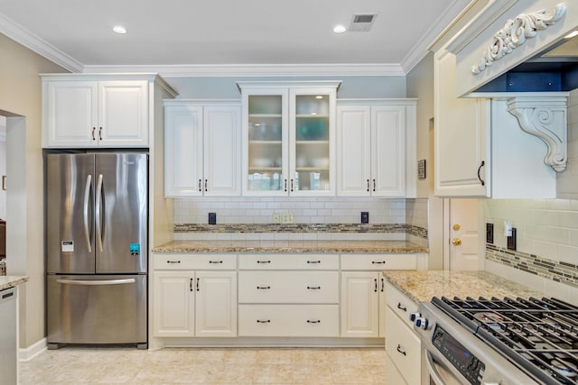 kitchen featuring appliances with stainless steel finishes, white cabinets, tasteful backsplash, light stone counters, and ornamental molding