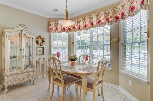 dining space with plenty of natural light, ornamental molding, and baseboards