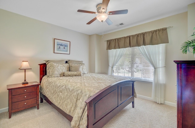 bedroom with light colored carpet, baseboards, and ceiling fan