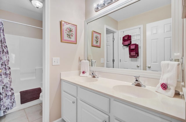 bathroom featuring tile patterned flooring, double vanity, and toilet