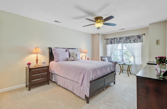 bedroom featuring light colored carpet, baseboards, and a ceiling fan