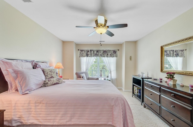 bedroom featuring light colored carpet, a ceiling fan, and baseboards