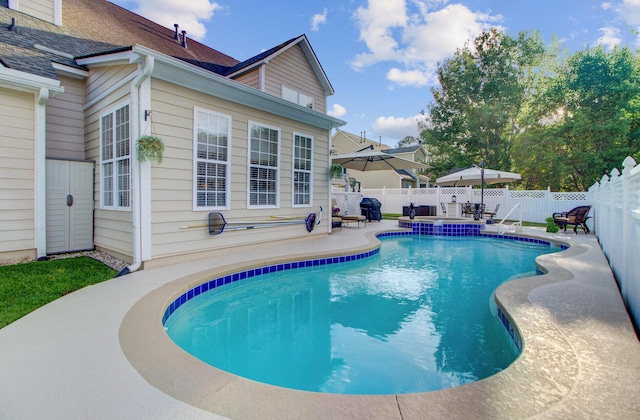 view of swimming pool with a patio area, a fenced backyard, and a pool with connected hot tub