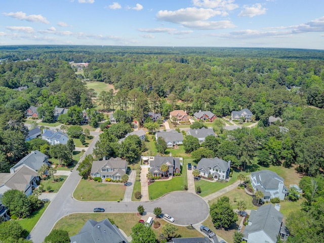 view of property location with a forest and nearby suburban area