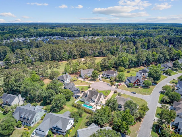 aerial view of property's location with a forest and nearby suburban area