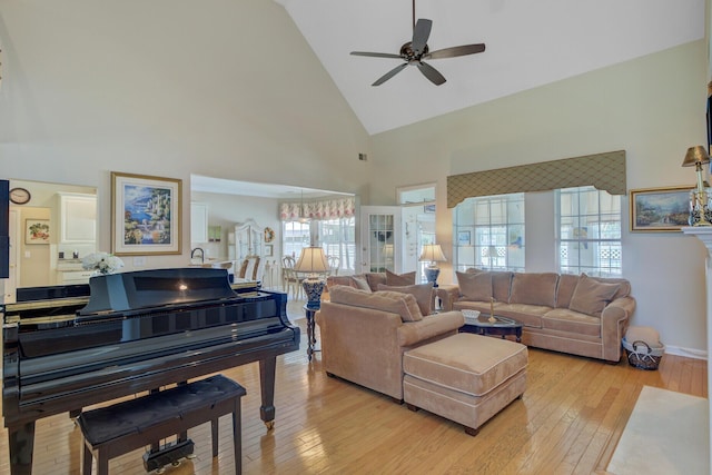 living area with high vaulted ceiling, a ceiling fan, and hardwood / wood-style floors