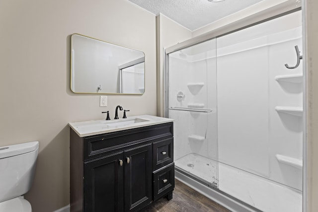 121 Harrison St, Varnville, SC 29944 - bathroom with wood finished floors, a textured ceiling, vanity, toilet, and a stall shower