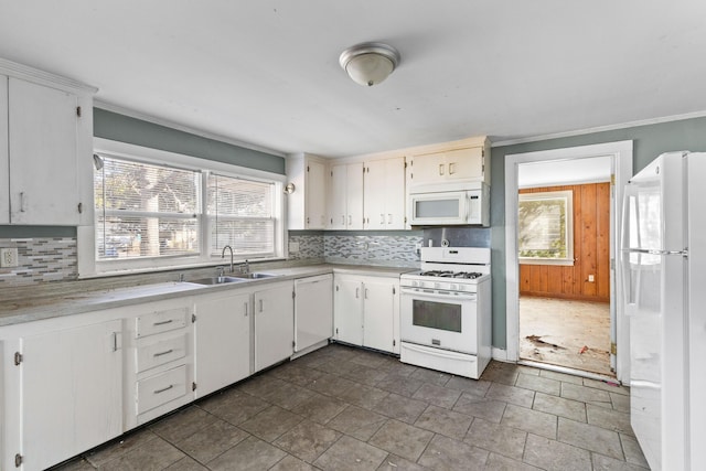 kitchen featuring light countertops, white appliances, plenty of natural light, and a sink