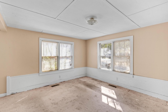 spare room featuring plenty of natural light, visible vents, and baseboards