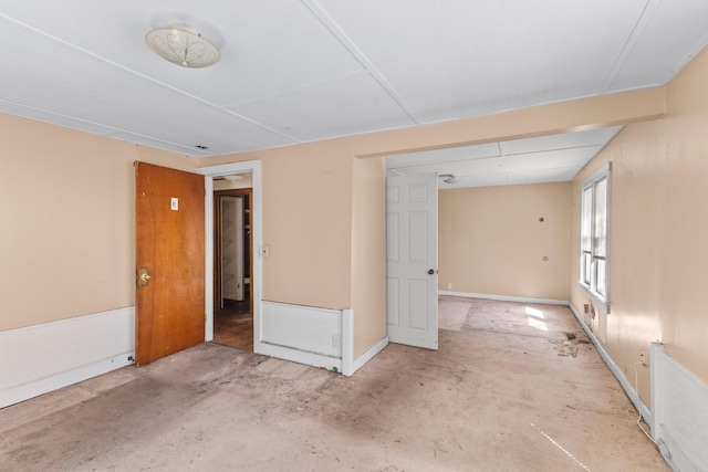 unfurnished room featuring baseboards and concrete flooring