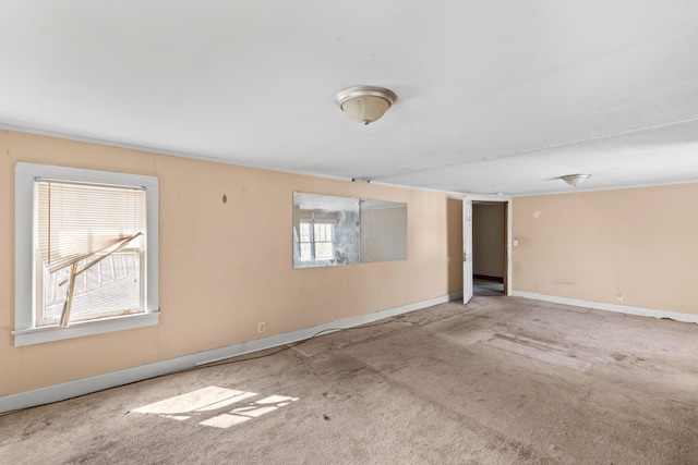 empty room featuring carpet and baseboards