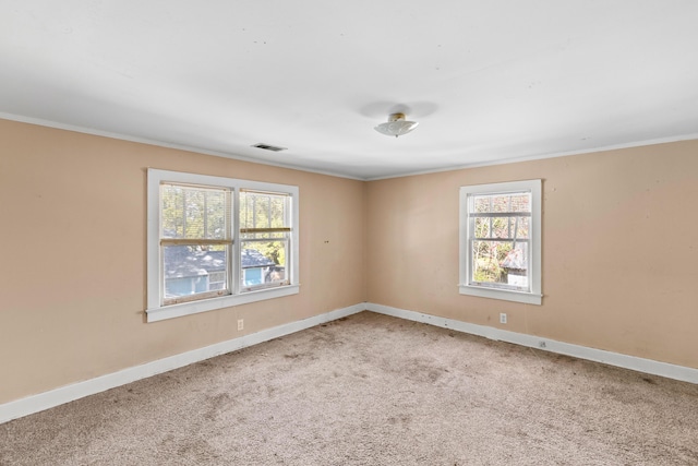 unfurnished room featuring carpet flooring, crown molding, visible vents, and baseboards