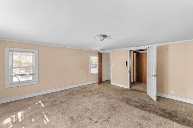 unfurnished bedroom featuring carpet floors, multiple windows, and baseboards