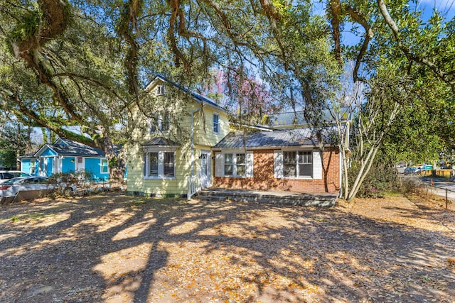 view of front of property featuring brick siding and fence