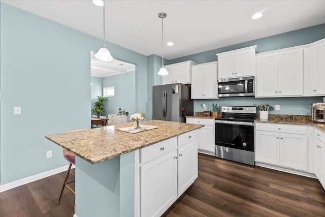 3055 Matthews Dr, Sumter, SC 29154 - kitchen featuring stainless steel appliances, dark wood finished floors, white cabinetry, a kitchen island, and light stone countertops