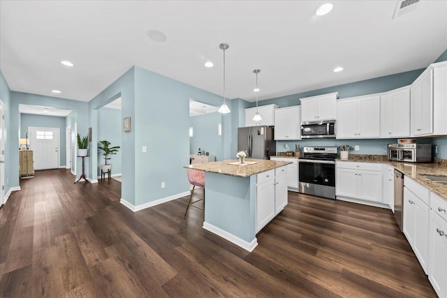 3055 Matthews Dr, Sumter, SC 29154 - kitchen with appliances with stainless steel finishes, a kitchen island, recessed lighting, light stone counters, and white cabinetry