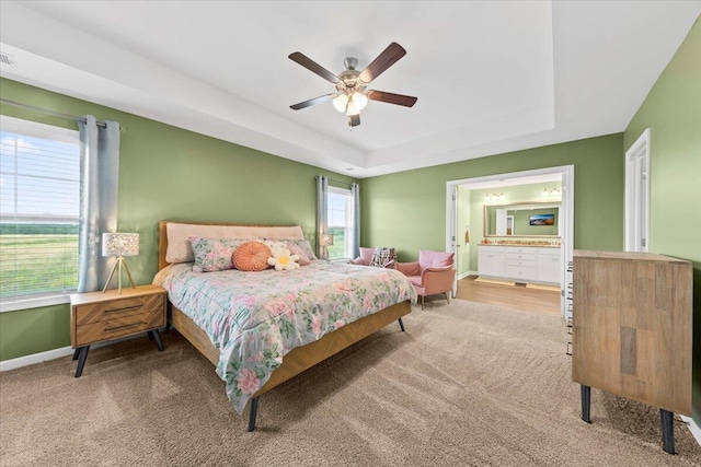 3055 Matthews Dr, Sumter, SC 29154 - carpeted bedroom featuring a raised ceiling, baseboards, a ceiling fan, and ensuite bathroom